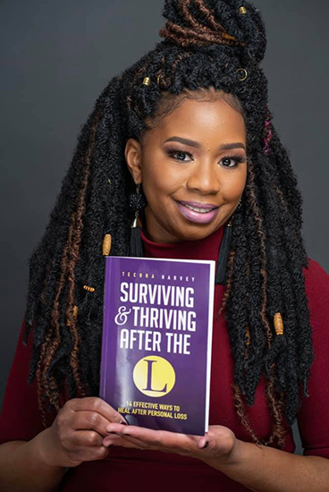 Author Tecora Harvey with her paperback book